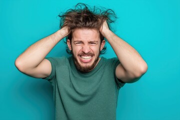 Frustrated man pulling hair in exasperation, showing intense stress and mental overload