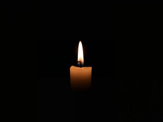 Candle Flame in Darkness. A Solitary Beacon of Light, a Symbol of Hope.