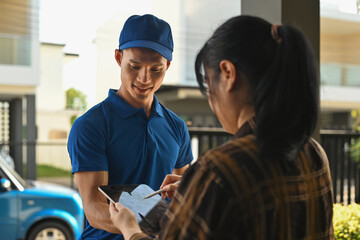 A Female customer signing on a tablet to confirm a package delivery from a smiling courier