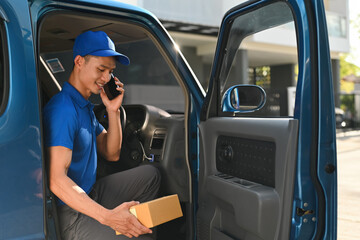 A Delivery man makes a call from his vehicle before completing a parcel drop-off © saltdium