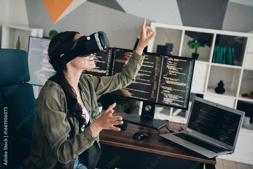 Poster young woman interacting with virtual reality while working on programming in a modern office setting