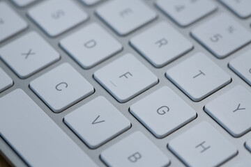 Modern white wireless keyboard as background, closeup