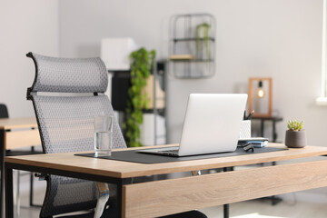 Stylish workplace with laptop and stationery on wooden table in office