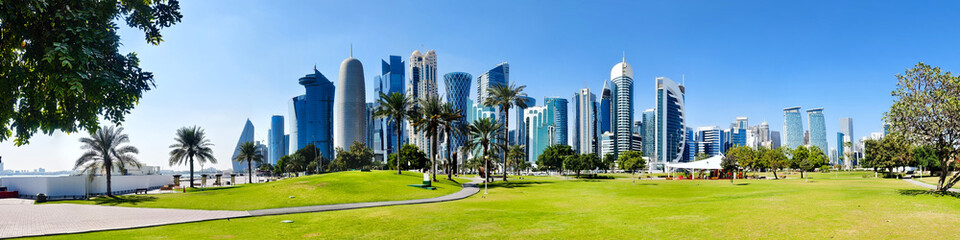 Tall modern skyscrapers tower over central park in Doha Qatar.