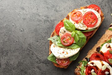Delicious sandwiches with mozzarella cheese and tomatoes on grey table, flat lay. Space for text
