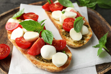Delicious sandwiches with mozzarella cheese, tomatoes and basil on grey table, closeup