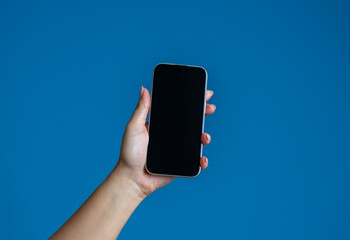 Hand Holding Smartphone with Blank Screen on Blue Background