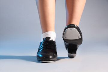 Teenage girl in tap shoes on light background, closeup