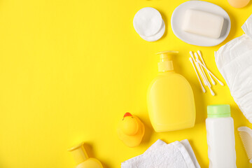 Baby accessories and cosmetic products on yellow background, flat lay. Space for text