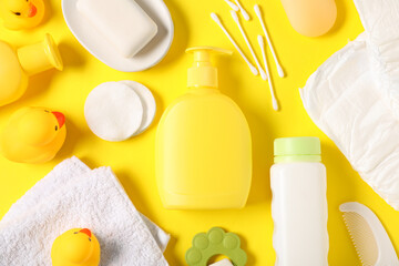 Baby accessories and cosmetic products on yellow background, flat lay