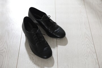 Pair of shoes for tap dance on floor indoors, above view. Space for text