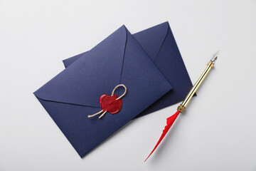 Envelopes with wax seal, twine and fountain pen on white background, flat lay