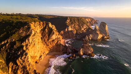 Aerial View of Rocky Coastline at Sunset with Waves Crashing on Shore