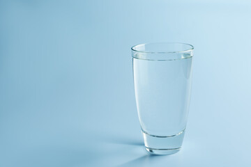 Refreshing soda water in glass on light blue gradient background, closeup. Space for text