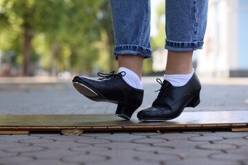 Teenage girl in tap shoes dancing outdoors, closeup