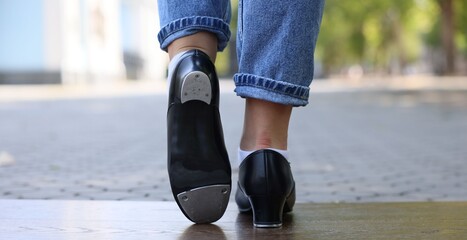Teenage girl in tap shoes dancing outdoors, closeup