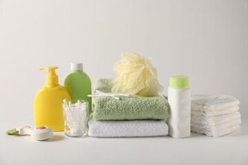 Baby accessories and body care products on light grey background