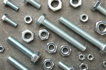 Metal bolts and nuts on grey table, flat lay