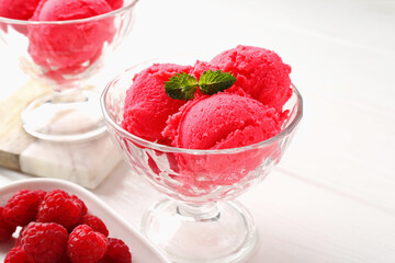 Delicious raspberry sorbet with mint in dessert bowl and fresh berries on white wooden table, closeup