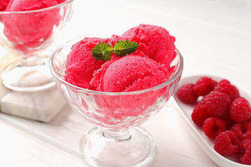 Delicious raspberry sorbet with mint in dessert bowl and fresh berries on white wooden table, closeup