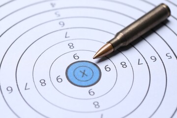 One metal bullet on shooting target, closeup