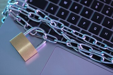 Cyber safety. Metal padlock with chain on laptop, top view