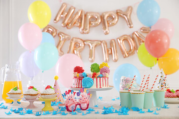Birthday celebration. Tasty cake and different treats on table in festive decorated room