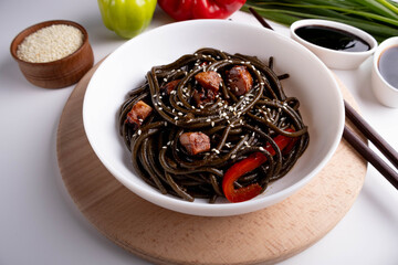 black pasta with vegetables on white background