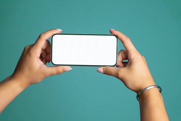 Hand Holding Smartphone with Blank Screen on Blue Background