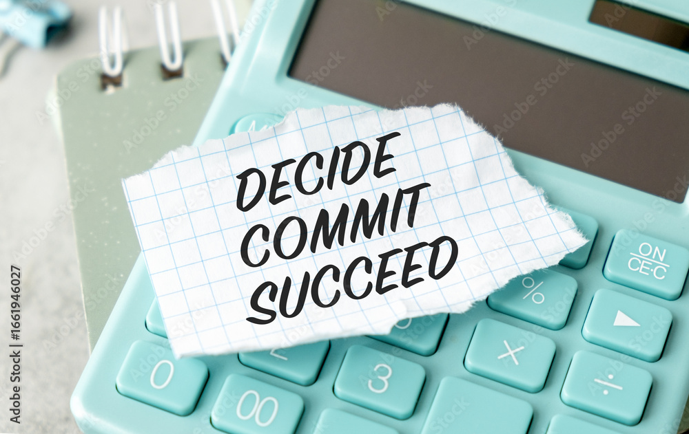 Poster a calculator sits on a desk with a piece of paper that says decide commit succeeded on it