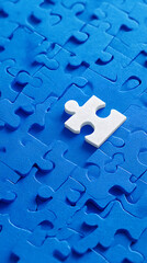 Fototapeta premium A single white jigsaw puzzle piece rests on a blue jigsaw puzzle background close up graphic design