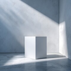 Fototapeta premium A stark white cube rests on a light grey concrete floor, bathed in angled sunlight streaming through a bare, textured wall