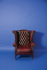 Vintage leather armchair against blue background