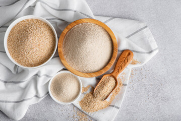 Raw organic amaranth grain and amaranth flour. Amaranth seeds in a wooden bowl on a table.