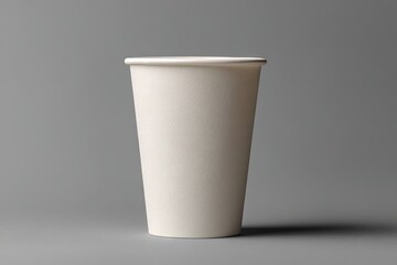A tall, off-white paper cup sits on a gray background, subtly shadowed to its right, showcasing its cylindrical shape and smooth texture
