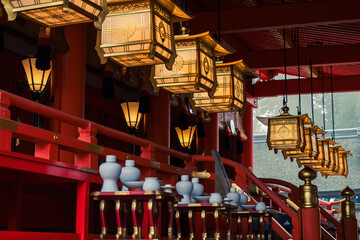 Interior of a Japanese Buddhist temple with large suspended lanterns, creating a sacred and atmospheric scene that blends tradition, spirituality, and the beauty of religious architecture.