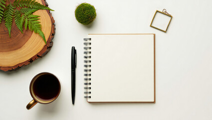 Workspace with blank notebook coffee fern and moss ball a serene and inspiring setup for creative thinking and planning