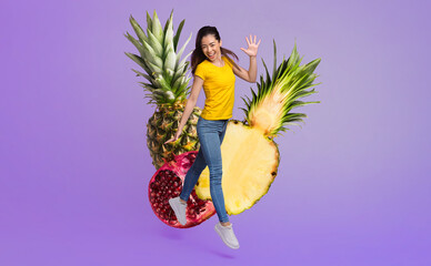 Asian woman is jumping in a joyful pose, wearing a yellow shirt and jeans, surrounded by tropical...