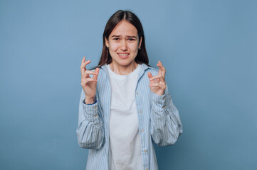 A young woman expressing frustration with a blue background.