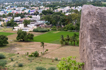 A large rock sits on a hill overlooking a town