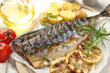 Tasty roasted mackerel served with spices and vegetables on table, above view. Homemade seafood dish