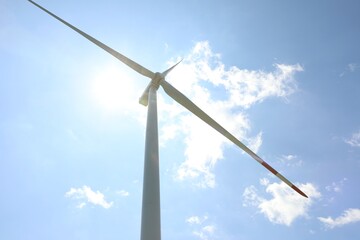 Modern wind turbine against blue sky, low angle view