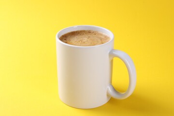 Aromatic coffee in cup on yellow background, closeup. Mockup for design
