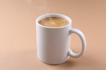 Aromatic coffee in cup on beige background, closeup. Mockup for design