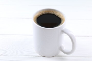 Aromatic coffee in cup on white wooden table, closeup. Mockup for design