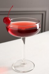 Tasty cherry cocktail on white table, closeup