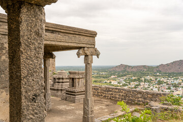 A stone building with pillars and a view of a city