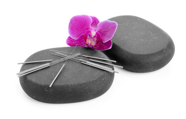 Acupuncture needles, orchid flower and spa stones isolated on white