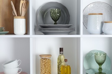 Shelving unit with different dishware, glasses and other kitchen utensils indoors