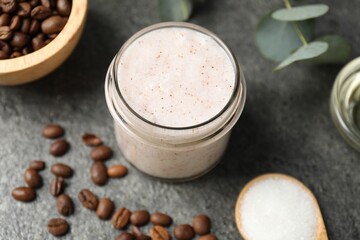 Natural body scrub in glass jar and ingredients on grey table, above view